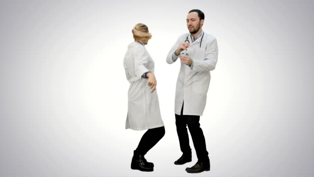 Two-funny-medical-doctors-with-funny-energy-dance-on-white-background
