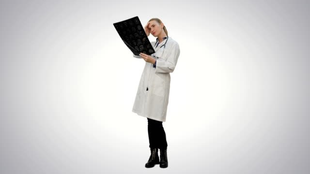 Female-doctor-looking-at-xray-of-human-brain-on-white-background