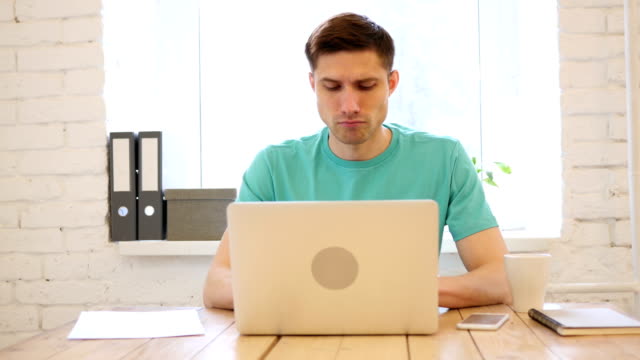 Cansado-joven-hombre-trabajando-en-ordenador-portátil,-carga-de-trabajo