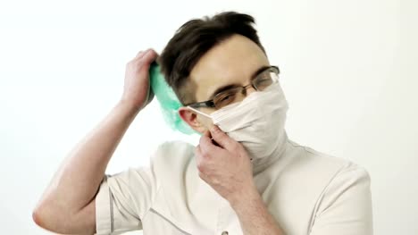 Young-surgeon-removes-the-mask-and-cap.
