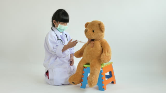 Asiatischen-Arzt-mit-Bär-Puppe-spielendes-Kind