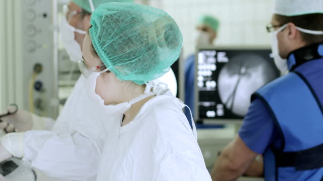 4K-The-team-of-surgeons-controls-the-operation-on-the-displays.