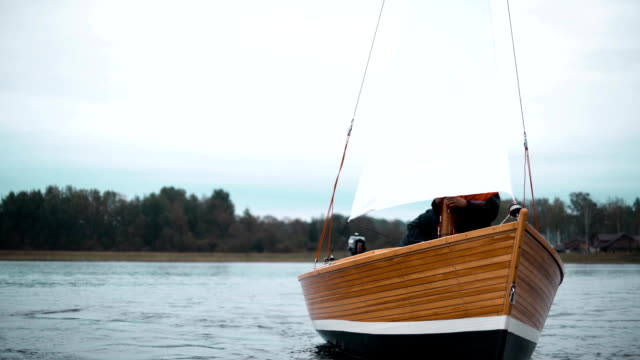 Holzboot-mit-zwei-Männern,-die-versuchen,-Mast-gesetzt