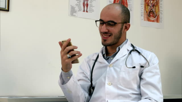 Medizinische-Arbeiter-überprüft-seine-Telefon-und-über-etwas-lachen