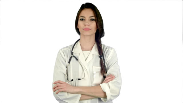 Atractivo-joven-mujer-doctor-en-bata-blanca-con-estetoscopio-mirando-a-la-cámara-sobre-fondo-blanco