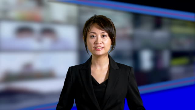 News-Moderatorin-im-Studio-mit-Banken-der-Bildschirme-im-Hintergrund