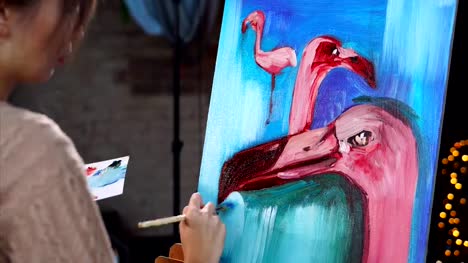 A-young-artist-paints-a-painting-with-oil-paints-with-a-flamingo