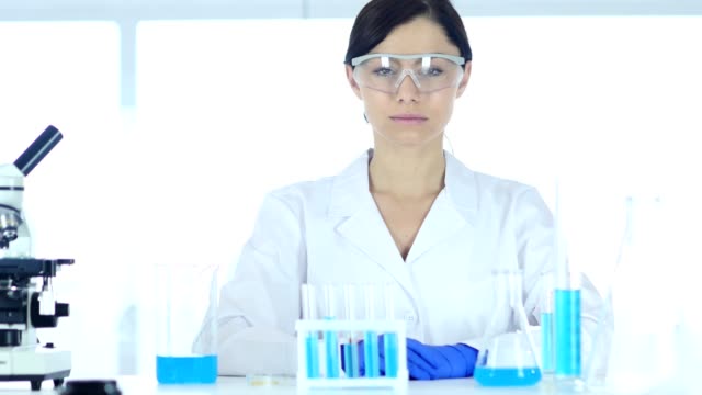 Reseach-Scientist-Sitting-in-Laboratory-Looking-at-Camera