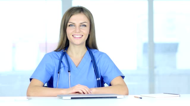 Portrait-of-Smiling-Positive-Female-Doctor-Sitting-in-Clinic