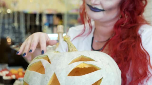 Close-up-portrait-of-redhead-woman-with-halloween-makeup-with-pumpkin.