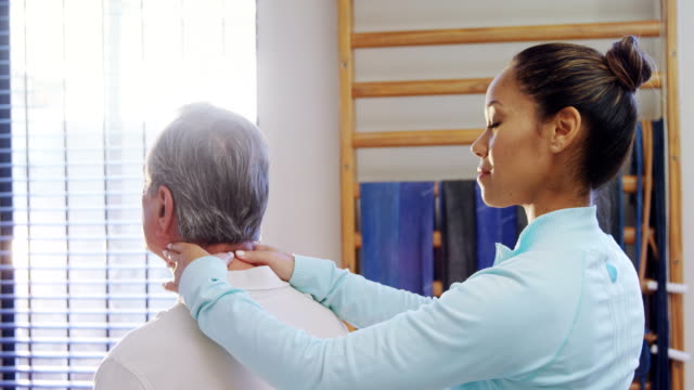 Porträt-von-glücklich-Physiotherapeuten-geben-Hals-massage-für-ältere-Patienten-4k