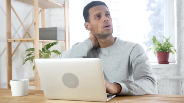 Nackenschmerzen,-müde-afro-amerikanischer-Mann-sitzen-bei-der-Arbeit