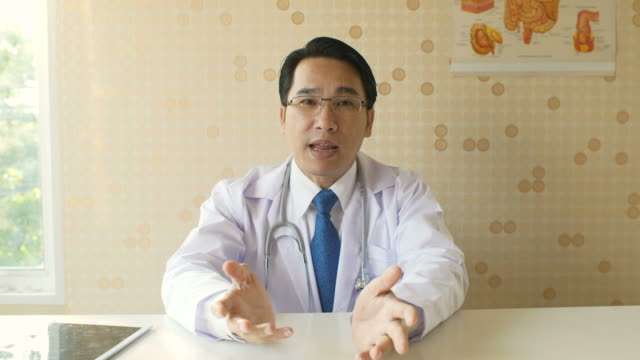 Männlichen-Arzt-im-Gespräch-mit-Patienten-bei-einem-Videoanruf-in-seinem-Büro