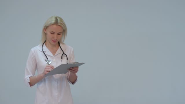 Porträt-von-einer-Ärztin-mit-weißen-Kittel-und-Stethoskop-lächelnd-in-die-Kamera-schauen
