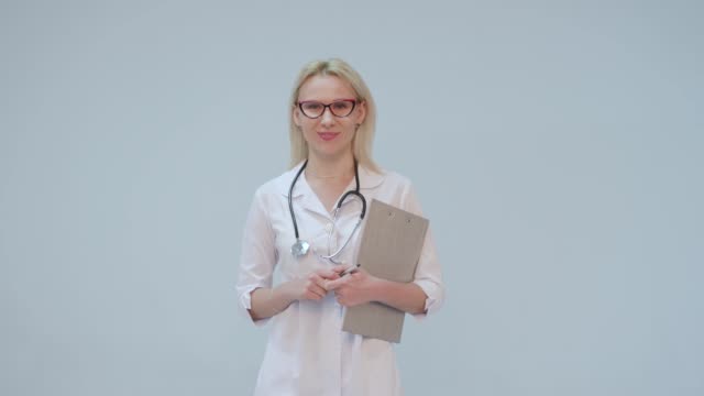 Porträt-von-einer-Ärztin-mit-weißen-Kittel-und-Stethoskop-lächelnd-in-die-Kamera-schauen