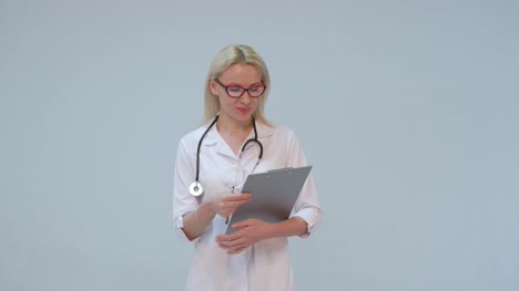 Mujer-médico-con-bata-blanca-y-estetoscopio-sonriendo-mirando-a-cámara