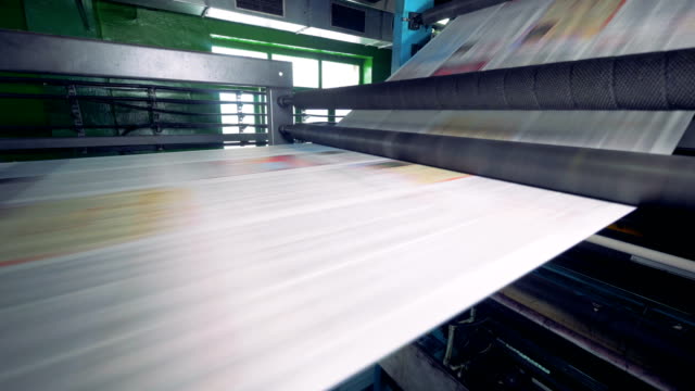 Newspaper-strip-on-a-printing-machine.-Detailed-view-on-a-printing-machine-in-action.-Newspapers-passing-near-camera.