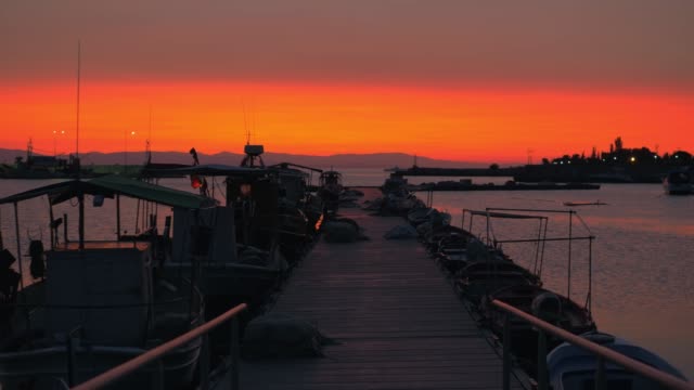 Abendstimmung-des-Kais.-Pier,-Boote-und-Orange-sky