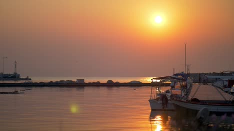 Wasserlandschaft-mit-Hafen-und-Boote-bei-Sonnenuntergang