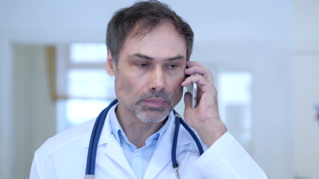 Doctor-Talking-on-Phone,-Attending-Phone-Call