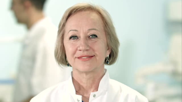 Smiling-senior-female-doctor-looking-at-camera