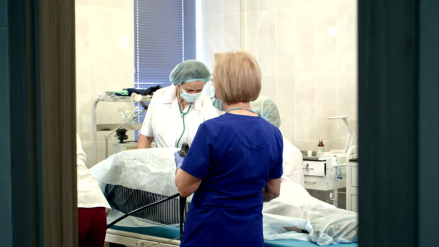 Doctors-managing-modern-endoscope-during-medical-procedure-at-hospital
