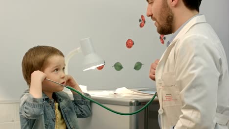 Young-boy-listening-to-doctor's-heart-with-stethoscope