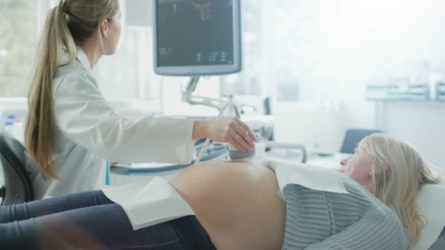 In-the-Hospital,-Obstetrician-Uses-Transducer-for-Ultrasound/-Sonogram-Screening-/-Scanning-Belly-of-the-Pregnant-Woman.-Computer-Screen-Shows-3D-Image-of-the-Healthy-Forming-Baby.