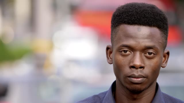 Stolz-schwarzen-afrikanischen-jungen-Mann-auf-der-Straße-in-die-Kamera-starrt