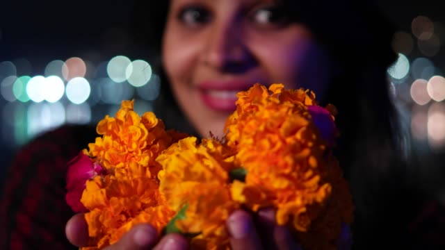 Beautiful-young-woman-hands-joined-in-namaste-greets-with-orange-marigold-flower-garland-on-her-neck-offers-prayers-worship-God-Goddess-hands-welcomes-smiles-glowing-respect-believer-religion-handheld