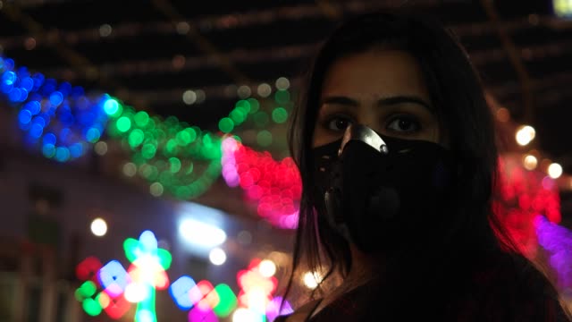 Junge-indische-Frau-trägt-Verschmutzung-Maske-zum-Schutz-vor-Schadstoffen-Atem-Lunge-Notfallvorsorge-Sicherheit-Maßnahme-Gesicht-Krankenversicherung-im-überfüllten-beschäftigt-indische-Stadt-Gefahr-schützen-handheld-Partikel