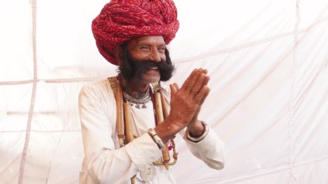 Sonriente-hombre-de-Rajasthan-con-bigote-grande-y-manos-Unidas-en-namaste-acoge-a-sus-huéspedes