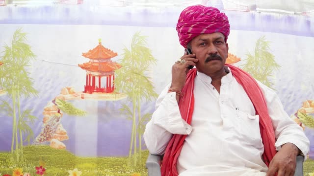 MS-of-Indian-man-seated-and-talking-on-the-phone-with-traditional-clothes