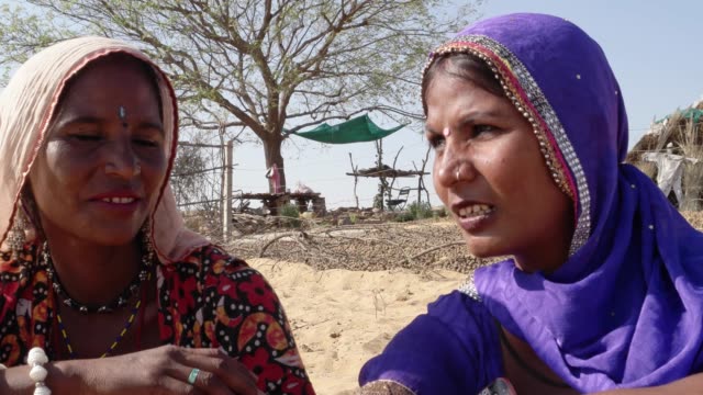 Nahaufnahme-von-Freunden-reden-vor-ihren-Hütten-in-Rajasthan,-Indien