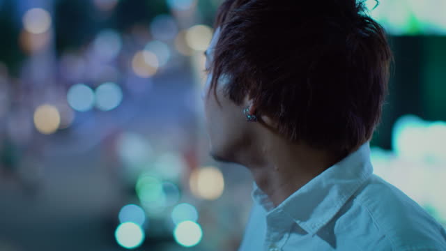 Portrait-of-the-Handsome-Young-Japanese-Man-Looking-at-the-Big-City-Lights.-In-the-Background-Big-City-Advertising-Billboards-Lights-Glow-in-the-Night.