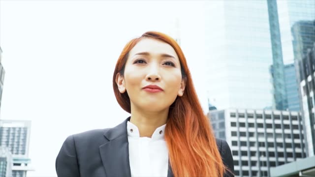 Nahaufnahme-Kamerafahrt-junge-attraktive-asiatische-Business-Frau,-die-zu-Fuß-in-die-Großstadt-Hintergrund