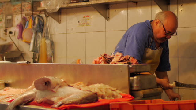 Ein-spanischer-Mann-wiegt-Fisch-auf-einem-Fischmarkt-in-Mexiko