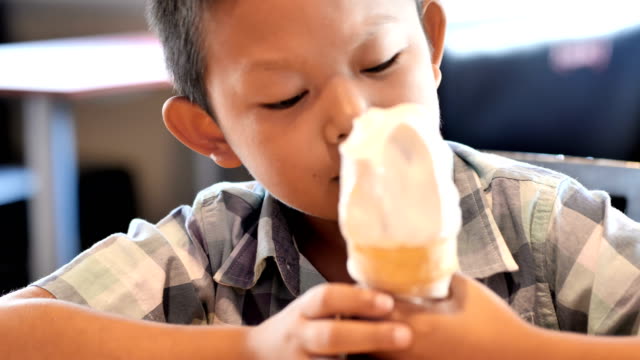 Niedlichen-asiatischen-jungen-gerne-Eis-essen-im-Restaurant.-4k-Video-Zeitlupe