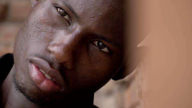 Porträt-von-traurig-nachdenkliche-junge-schwarze-Afrikaner-an-die-Wand-gelehnt