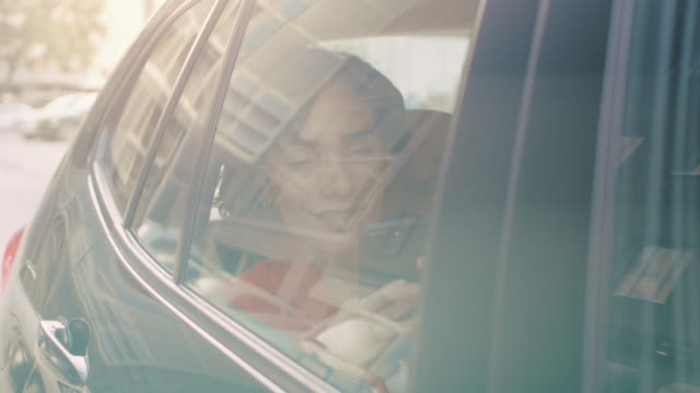 Beautiful-Woman-Rides-in-a-Car,-Sitting-on-a-Passenger-Backseat-Uses-Smartphone,-Browses-Through-Internet,-Chats-with-Friends.-Camera-Shot-from-Outside-the-Vehicle.