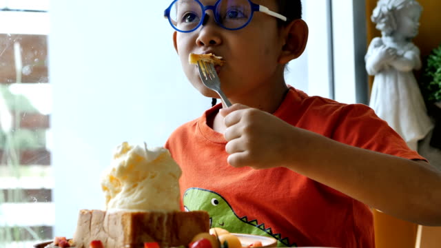 Süße-asiatische-Kinder-glücklich-essen-Eis-im-restaurant