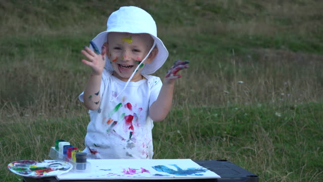 Happy-child-painting,-smiling-clapping-hands,-dirty-face,-hands,-clothes