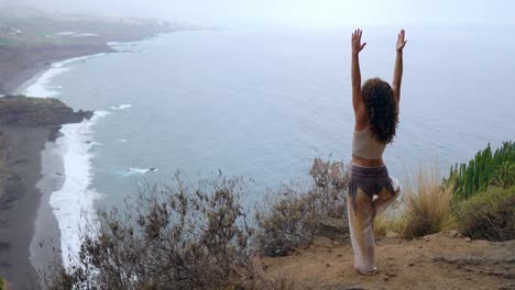 Mujer-joven-haciendo-yoga-en-una-costa-rocosa-al-atardecer.-El-concepto-de-un-estilo-de-vida-saludable.-Armonía.-Humanos-y-la-naturaleza.-El-fondo-del-océano-azul.