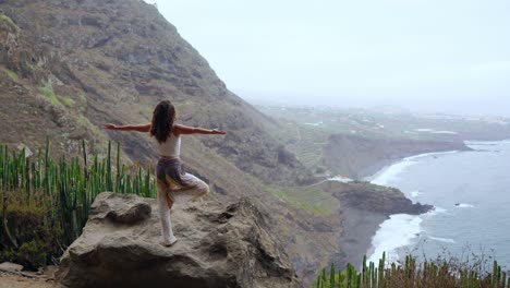 Young-woman-meditate-on-the-top-of-mountain