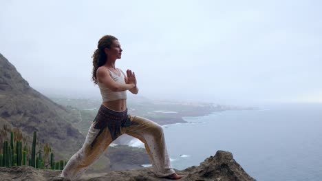 Mujer-joven-haciendo-yoga-en-una-costa-rocosa-al-atardecer.-El-concepto-de-un-estilo-de-vida-saludable.-Armonía.-Humanos-y-la-naturaleza.-El-fondo-del-océano-azul.