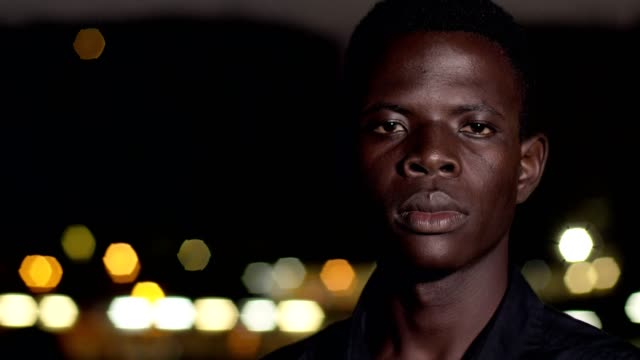 Stolz-auf-ernsthafte-junger-afrikanischer-schwarzer-Mann-starrte-auf-Kamera-in-der-Nacht