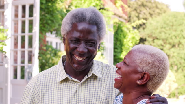 Senior-pareja-negra-abrazándose-y-sonriendo-en-un-jardín