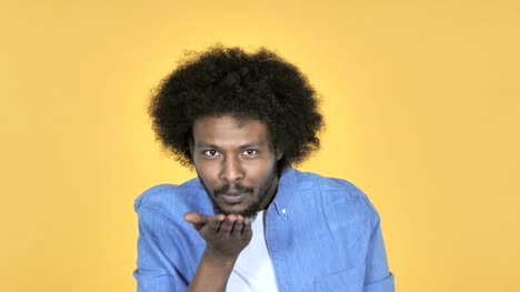 Flying-Kiss-by-Afro-American-Man-on-Yellow-Background