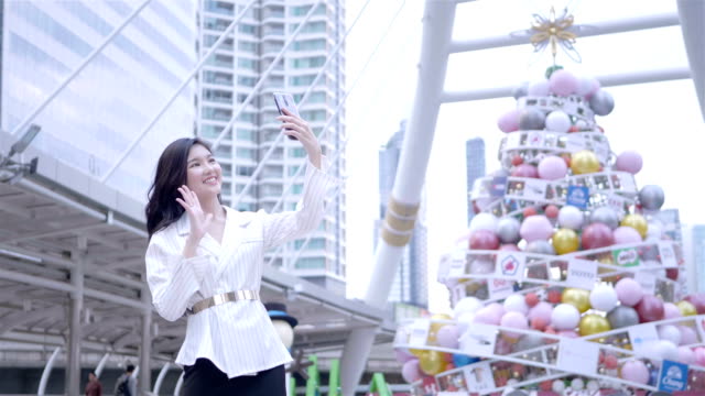 Junge-asiatische-Geschäftsfrau-mittels-Smartphone-nehmen-Selfie,-glücklich-lächelnd-im-Stadtzentrum-von-Bangkok,-Thailand.-täglichen-Lebens-Technologiekonzept.-SLOW-MOTION