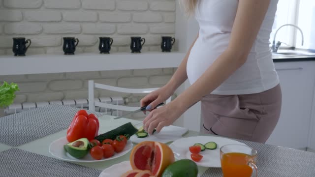 estilo-de-vida-saludable-de-la-mujer-embarazada-con-Panza-grande-cocina-útil-deliciosa-comida-para-la-cena-de-verduras-frescas-en-la-cocina